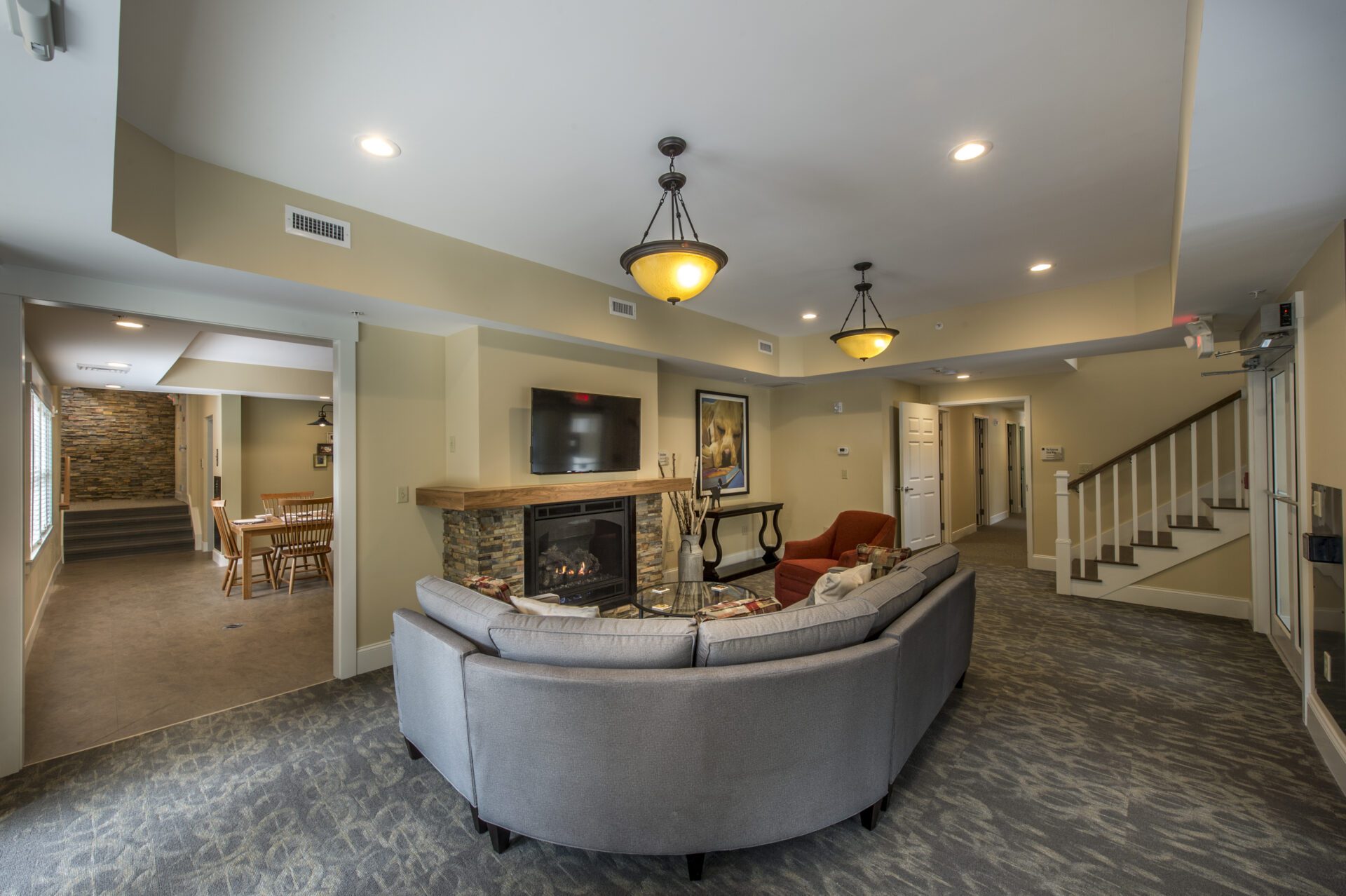 A living room with grey sofa and tv in wall