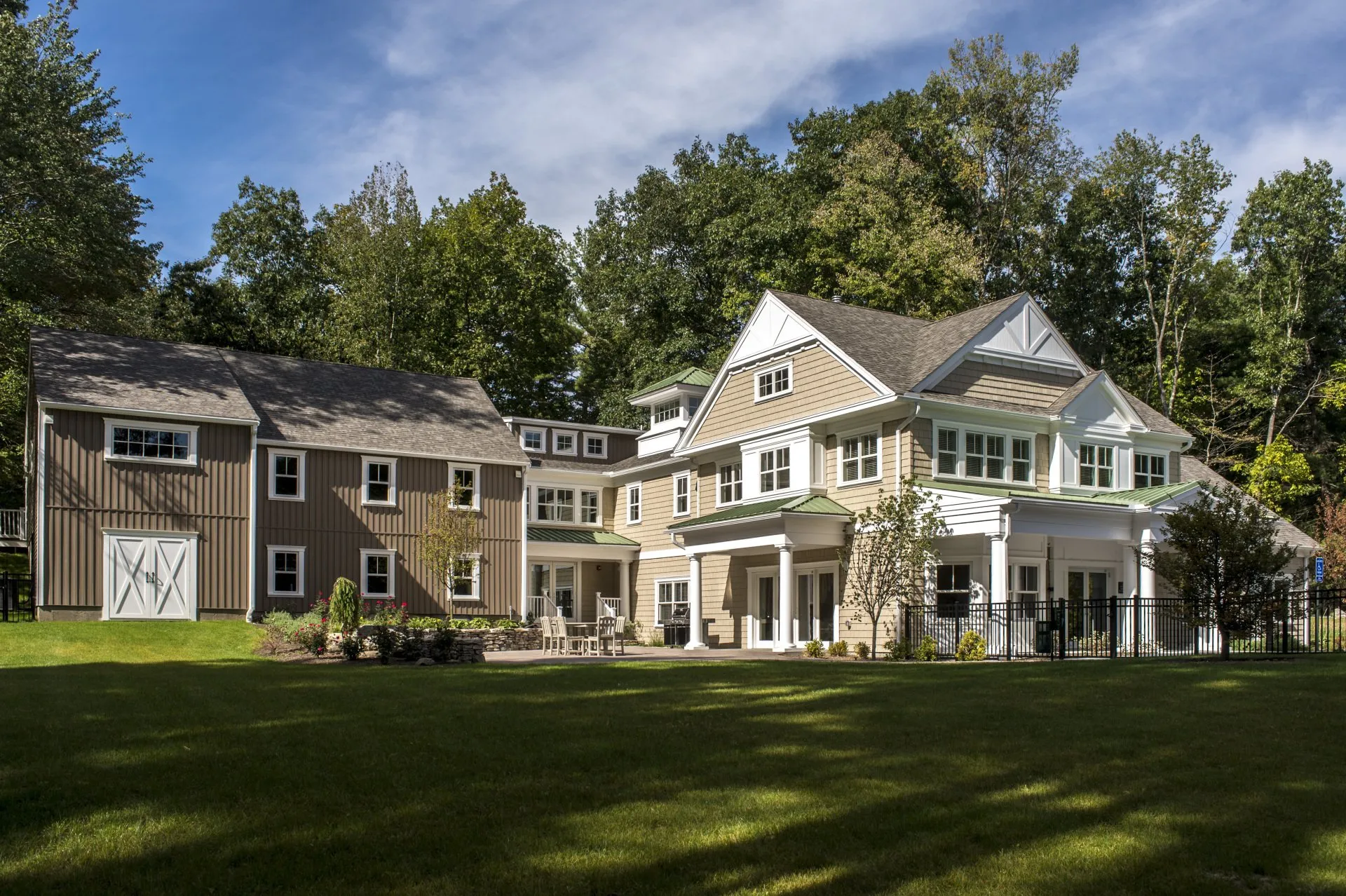 A beautiful white house beside a lot of tall trees